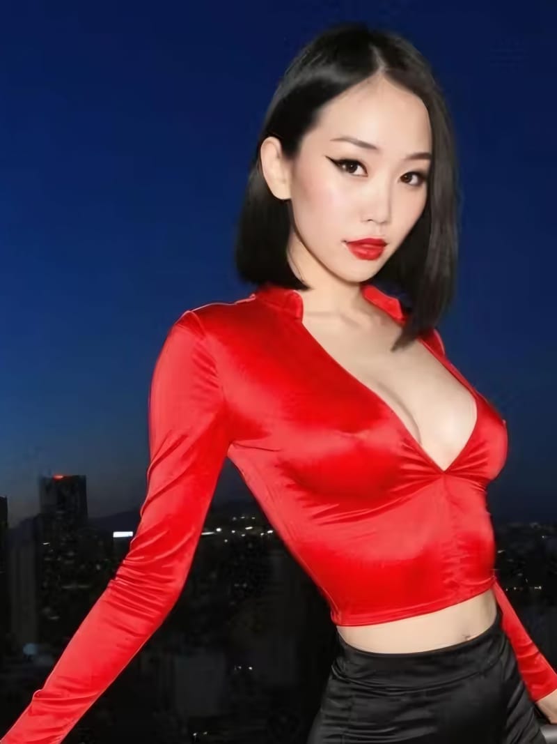 AI-generated adult woman in a red satin top on a night balcony above a city